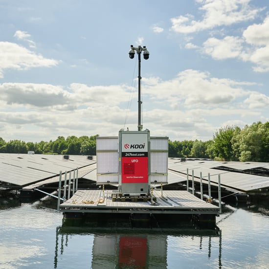 Industrieel of havengebied met tijdelijke werfinrichting en mobiele camera-unit voor continue bewaking van het terrein.
