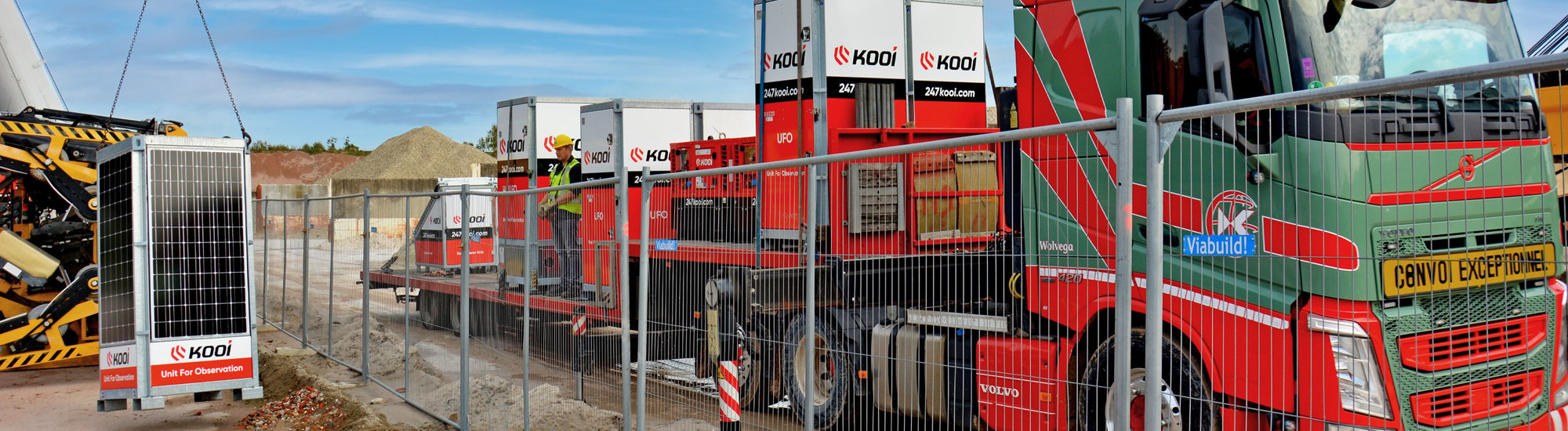 On a construction site, a mobile surveillance pole is being offloaded from a truck by a crane, showcasing its easy deployment and mobility.