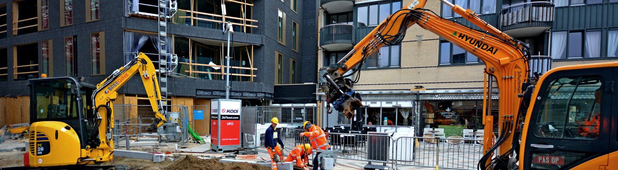 In a bustling city construction site, workers operate as the Unit for Observation (UFO) stands ready, providing mobile surveillance.