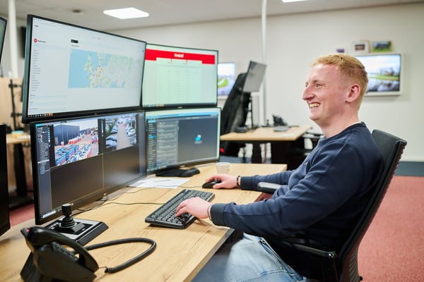 Kooi employee monitoring multiple screens in a control room, highlighting a reliable, innovative, and technology-driven approach to security management.