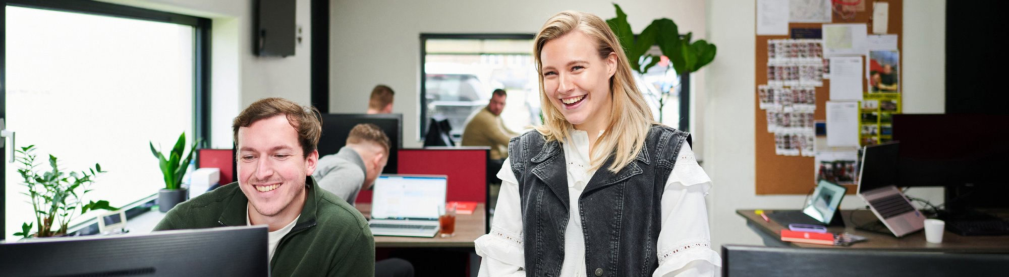 Two colleagues sharing a laugh at the office, Showing the team spirit at Kooi, where innovative security solutions like the UFO & RED are developed